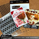Crafting supplies including stencils, transfer sheets, and decorative cards on a brown surface.