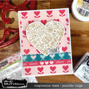 Card with heart design and 'Thanks' text on a wooden surface with craft supplies.