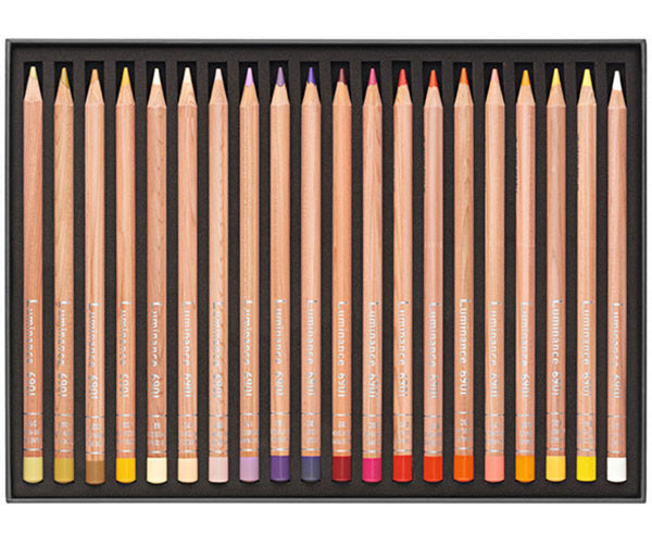 Set of colored pencils with color swatches on a black tray