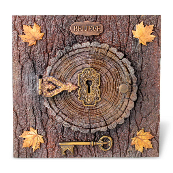 Decorative wooden plaque with keyhole, key, and 'BELIEVE' sign on a tree bark background.
