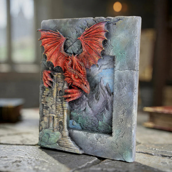Decorative book with a dragon and castle design on a stone surface.