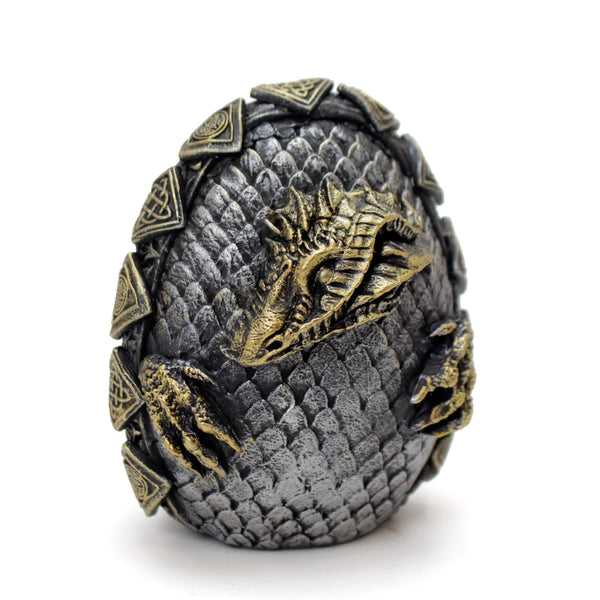 Decorative dragon egg with detailed scales and head on a white background