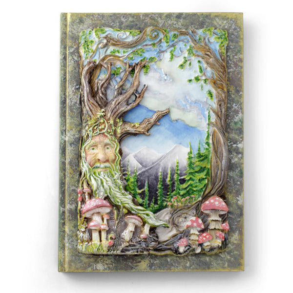 Decorative notebook cover with a forest-themed design featuring a face among trees and mushrooms.