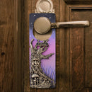 Decorative door handle cover with fantasy design on a wooden door