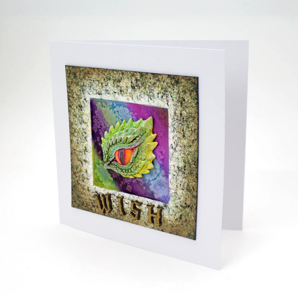 Greeting card with dragon eye design and 'Wish' text on a textured background