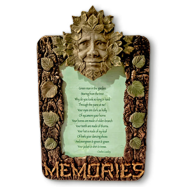 Decorative plaque with a leafy face design and 'Memories' text on a white background