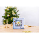 Christmas card with angel design on a wooden surface with a blurred Christmas tree in the background.