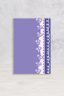 Notebook with decorative ribbon pattern on a textured surface