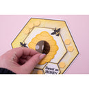 Hand holding a honeycomb-shaped card with a bee on a pink background