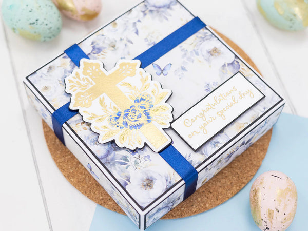 Decorative gift box with floral design and blue ribbon on a light background