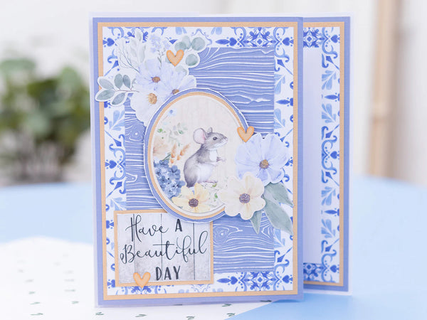 Greeting card with decorative border and mouse illustration on a blue background