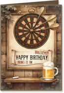 Birthday card with dartboard, darts, and a glass of beer on a wooden background