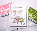 Card with a bunny and flowers design, surrounded by Gina K. products on a white background