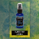 Blue bottle of Dylusions Ink Spray with a green textured background
