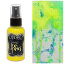 Bottle of Dylusions Lemon Drop Ink Spray with a colorful splatter design on paper.
