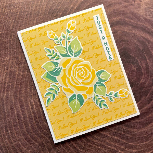 Greeting card with yellow rose design and 'Just a Note' text on a wooden surface