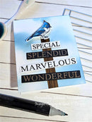 Card with blue jay illustration and text on a wooden surface