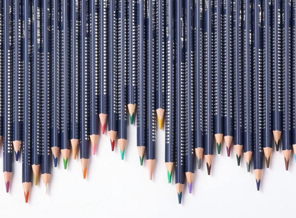 Row of black pencils with colored tips on a white background