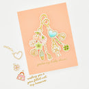 Decorative keychain charms on a peach card with text