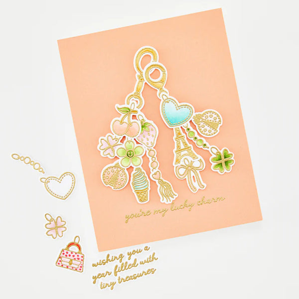 Decorative keychain charms on a peach card with text