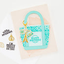 Teal gift bag with decorative elements on a light background
