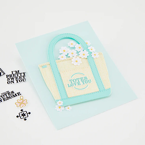 Card with a small bag and flowers on a light blue background