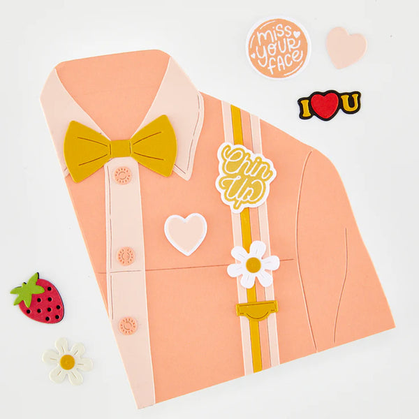 Decorative paper shirt with bow tie, flowers, and text on a light gray background