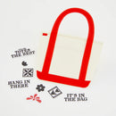 White tote bag with red handles on a light gray background with motivational phrases.