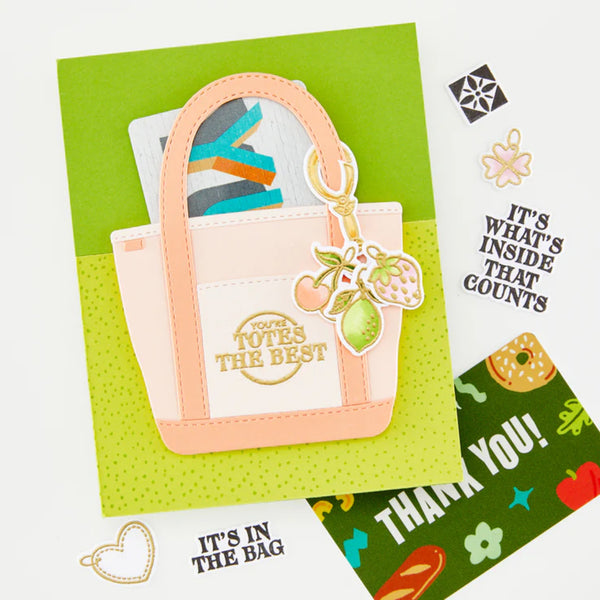 Card with a pink tote bag and keychain on a green background