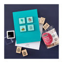 Set of wooden stamps with a teal card and ink pad on a dark blue background