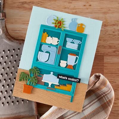 Decorative kitchen-themed card with cut-out elements on a wooden surface