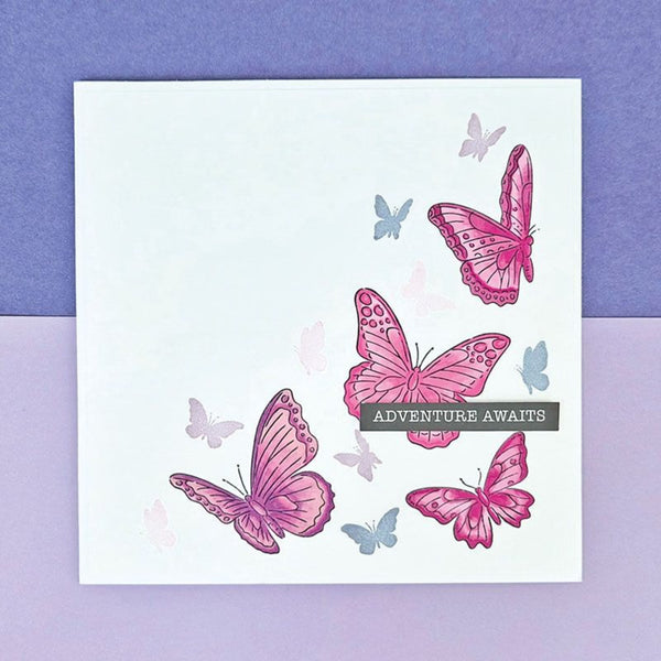 Card with pink and blue butterflies and 'Adventure Awaits' text on a purple and white checkered background