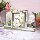 Floral card with white flowers on a wooden surface with flowers and ribbons.