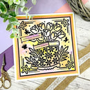 Decorative card with floral design and 'Birthday Wishes' text on a wooden surface with scissors and plants.