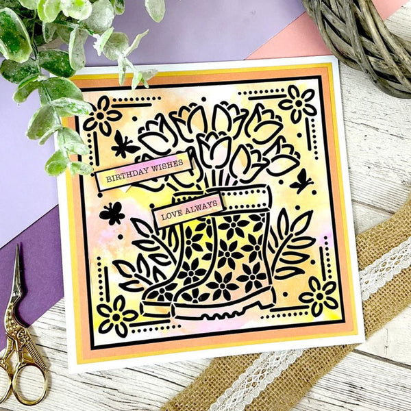 Decorative card with floral design and 'Birthday Wishes' text on a wooden surface with scissors and plants.