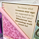 Card with humorous text and floral design on a pink background
