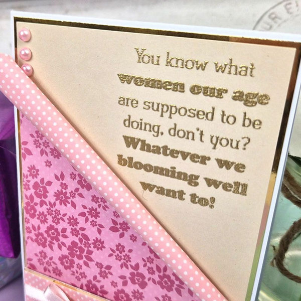 Card with humorous text and floral design on a pink background
