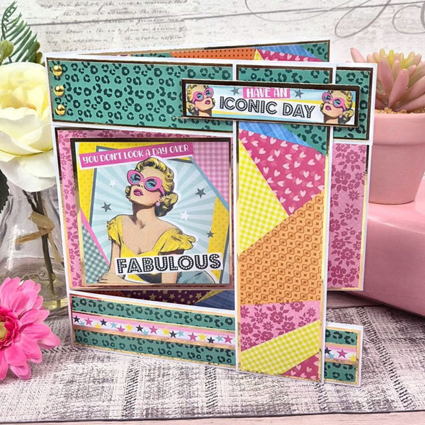 Colorful card with patterned design and text on a textured surface with flowers and a plant.