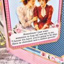 Vintage-style card with two women hugging, surrounded by flowers and text.