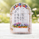 Decorative window frame with flowers and text on a blurred natural background