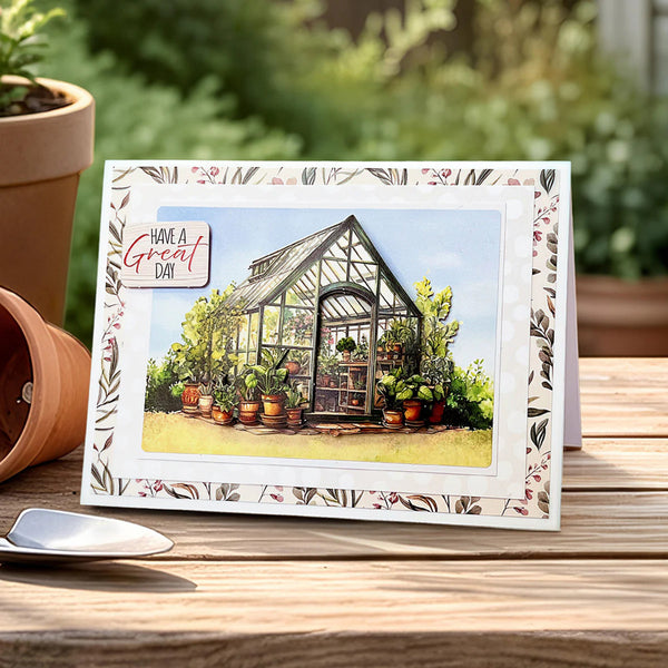 Greeting card with a greenhouse illustration and 'Have a Great Day' message on a wooden surface with plants.