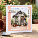 Garden-themed birthday card with a small shed and plants on a wooden surface.