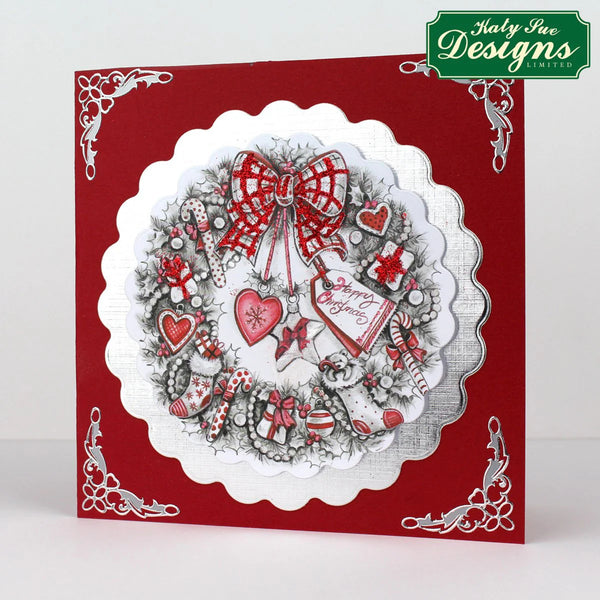 Decorative card with a wreath design featuring hearts and a bow on a red background, branded 'Kathy Nee Designs'.
