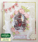 Decorative card with floral elements and a small house illustration, featuring the brand 'Nancy Sue Designs'.