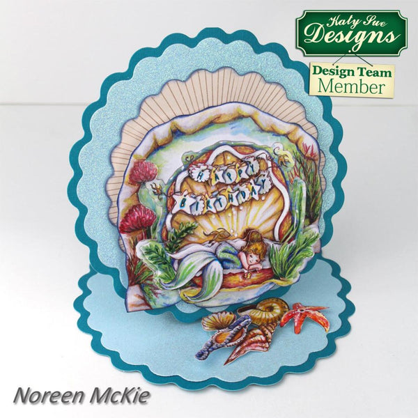 Decorative card with mermaid design inside a shell, featuring 'Kathy Sue Designs' on a white background.