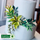 White cake with green leaf decoration on a white background