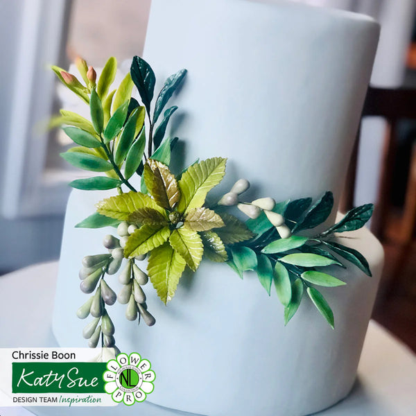 White cake with green leaf decoration on a white background