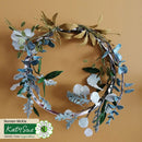 Floral wreath with green and white leaves on a beige background, featuring Katy Sue Design branding.