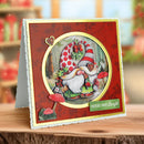 Decorative Christmas card with a gnome design on a wooden surface.