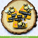 Three bee-shaped decorative items with text on a wooden surface